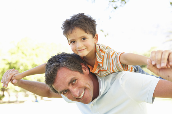 A father gives his son a piggyback ride.