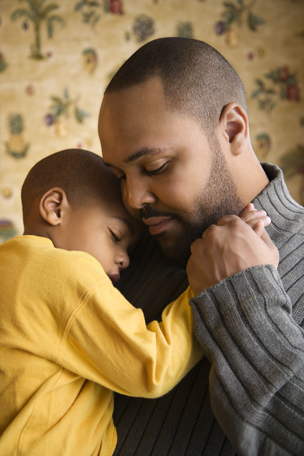 A father hugs his young son.